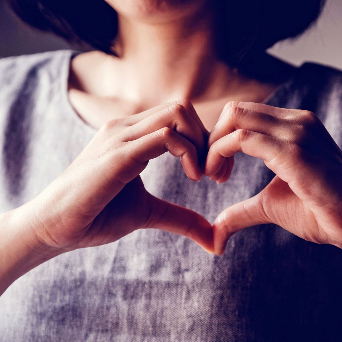Woman holding heart hands